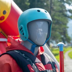 A mannequin in a red life jacket next to an inflatable boat