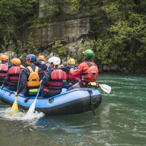 Group of people rafting in rubber dinghy on a river